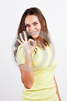 Portrait of smiling young woman gesturing okay