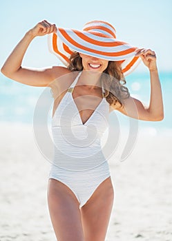 Portrait of smiling young woman in hat on beach