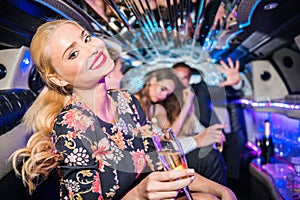 Portrait of smiling young woman holding champagne flute with fri