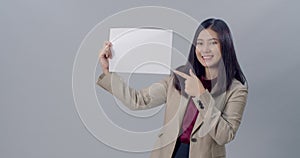 Portrait of smiling  young woman holding white poster to presenting