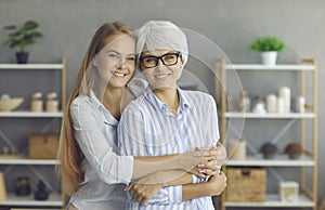 Portrait of a smiling young woman hugging her happy mature mother or grandmother