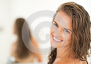 Portrait of smiling young woman with long wet hair