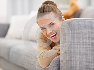 Portrait of smiling young woman looking out from divan