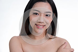 Portrait of a smiling young woman with natural make-up. beautiful asian girl standing against white background.