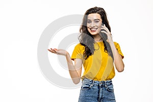 Portrait of a smiling young woman talking on mobile phone isolated over white background