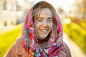 Portrait of smiling young woman wearing headscarf in city