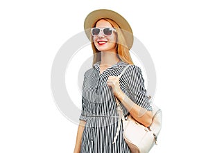 Portrait of smiling young woman wearing summer straw hat, striped dress and backpack isolated on white background