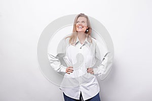 Portrait of smiling young woman in white shirt standing over white background and looking away