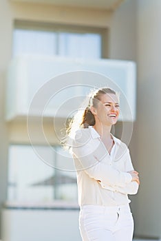 Portrait of smiling ywoman standing in front of house building