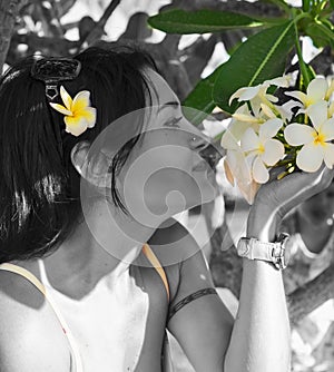 Portrait of sniffling  woman with plumeria frangipane . beauty concept. close up photo