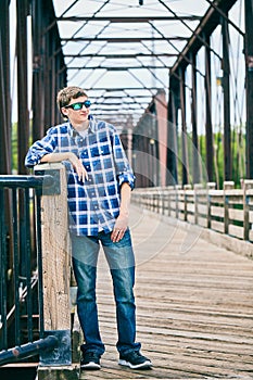 Portrait of snobbish young man standing on bridge