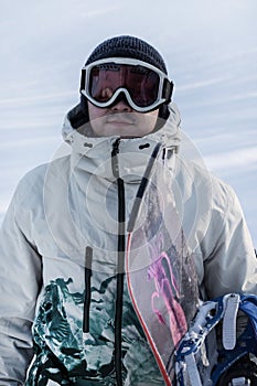 Portrait of a snowboarder in goggles at a ski resort, close-up.