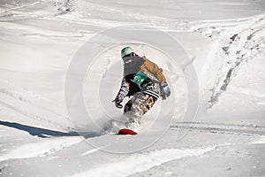Portrait of the snowboarder in sportswear riding down the snow slope