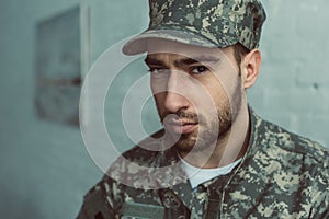 portrait of soldier in military uniform looking at camera against white