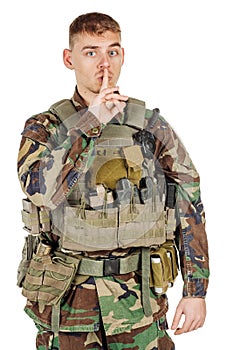 Portrait soldier or private military contractor with finger on lips asking for silence