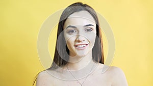 Portrait of the speaking girl with balanced emotion on yellow background in 4K