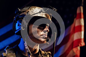 Portrait of special forces soldier in glasses and helmet against US national flag