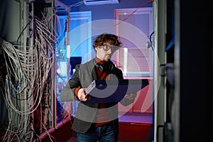 Portrait of it specialist holding hardware in hand standing in server room