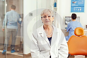 Portrait of specialist senior dentist woman in stomatological office