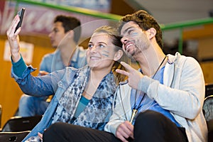 Portrait spectators doing selfie