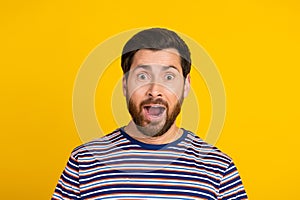 Portrait of speechless guy with stylish stubble wear striped t-shirt astonished staring open mouth isolated on yellow photo