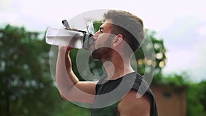 Portrait of sport man drinking mineral water after outdoor workout