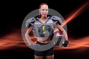 Portrait of a sportive girl in the uniform of an American football team player. Sports concept. Futuristic background