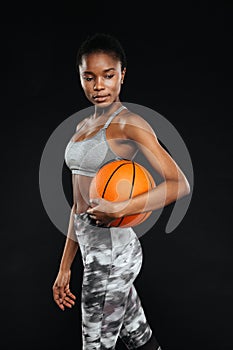 Portrait of a sports woman posing holding ball