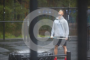 Portrait of a sportsman having rest after hard workout outdoor in a rainy day.