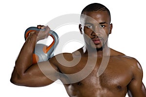 Portrait of sportsman lifting kettlebell photo