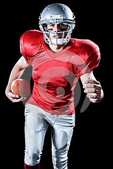 Portrait of sportsman running while playing American football