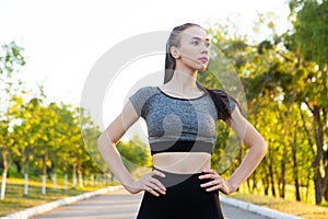 Portrait of sporty athletic woman in sportswear on running road in the park.