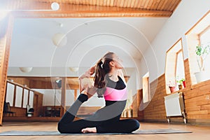 Portrait of sporty beautiful blond woman in sportswear working out indoors, doing variation of Upward Plank Posture, Eka