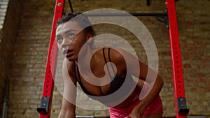 Portrait of sporty fit african woman practicing weight training with dumbbells