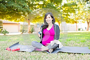 Portrait of a sporty pregnant woman drinking water