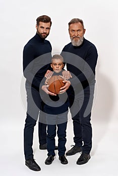 Portrait of sporty three generations of men with ball