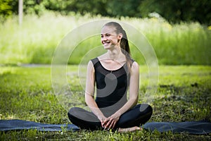 Portrait of sporty woman doing stretching exercises in park before training. Female athlete preparing for jogging