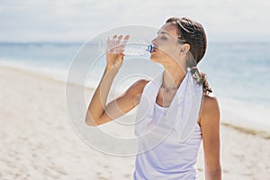 Sporty woman drinking mineral water after workout