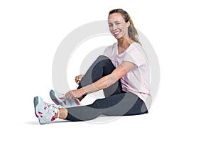 Portrait of sporty woman smiling while tying shoelace