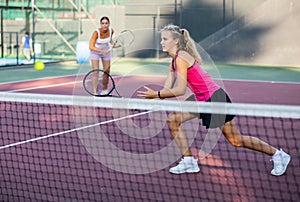 Portrait of sporty young woman in activewear playing tennis on court, ready to hit ball. Active lifestyle concept
