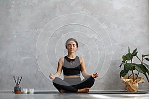 Portrait of sporty young woman doing exercises on yoga lesson at home. Beautiful girl practicing easy yoga pose