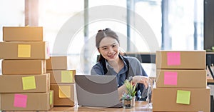 Portrait of Starting small businesses SME owners, Asian woman check online orders Selling products online and working with boxs