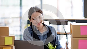 Portrait of Starting small businesses SME owners, Asian woman check online orders Selling products online and working with boxs