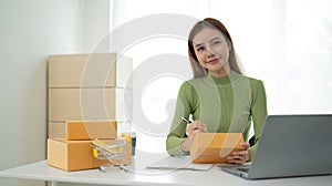Portrait of Starting small businesses SME owners female entrepreneurs working on receipt box and check online orders to