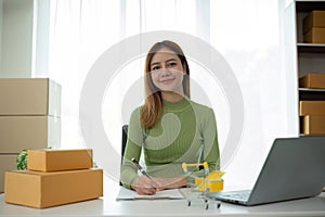 Portrait of Starting small businesses SME owners female entrepreneurs working on receipt box and check online orders to