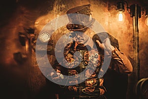 Portrait of steampunk man with various mechanical devices on vintage steampunk background