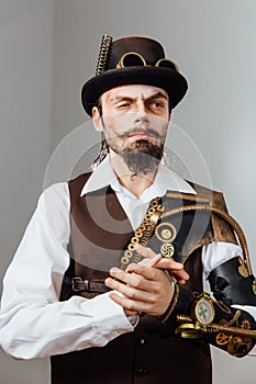 Portrait of steampunk vintage man with various mechanical devices on body.