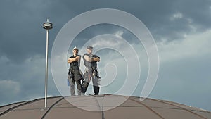 Portrait of steeplejacks on the roof against the sky