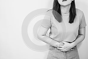 Portrait stomach ache sick and pain feeling of woman 30s to 40s with monochrome and red spot on hurt point