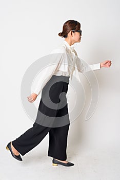 Portrait of stressed Asian businesswoman with eyeglasses running away